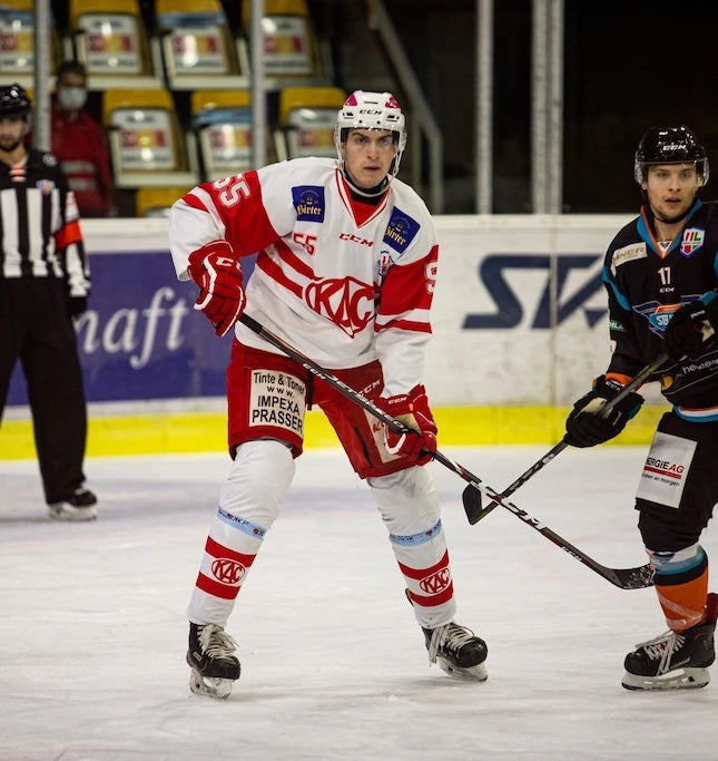 Johannes Patterer in Aktion am Eis verteidigt Gegner, mit fokussiertem Blick, in der Alps Hockey League